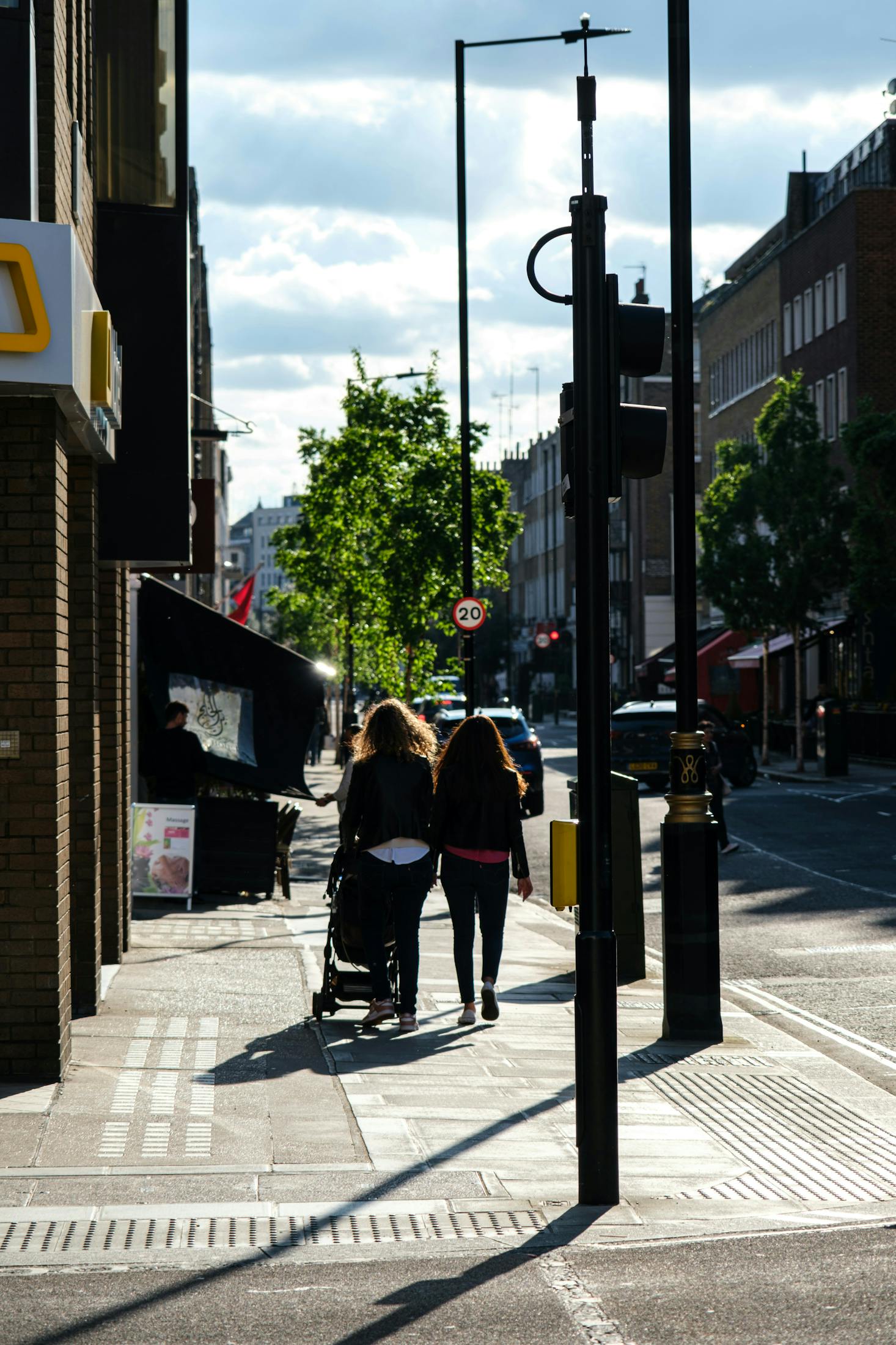 A couple pushing a stroller down Chiltern Street in Marylebone, London on a sunny day