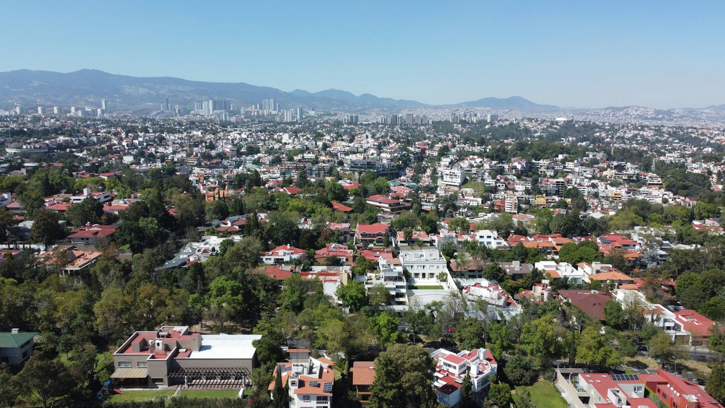 Aerial view of the rooftops of Mexico City with mountains in the distance