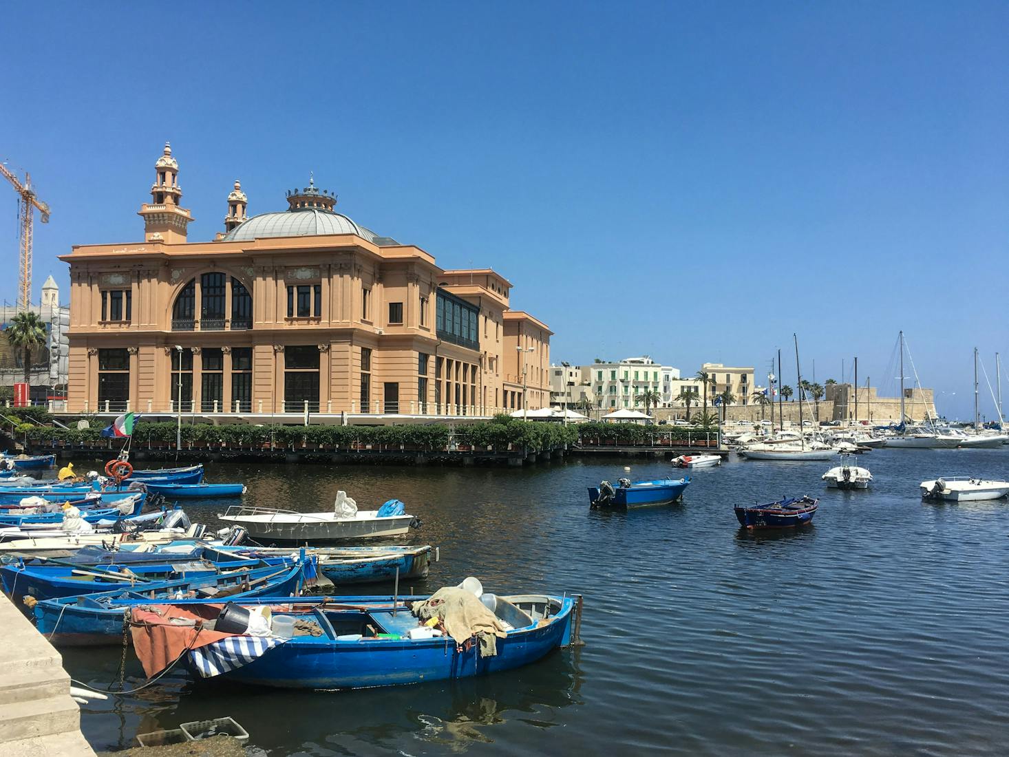 Vista sul mare di Bari, con barche ormeggiate in primo piano ed edifici sullo sfondo