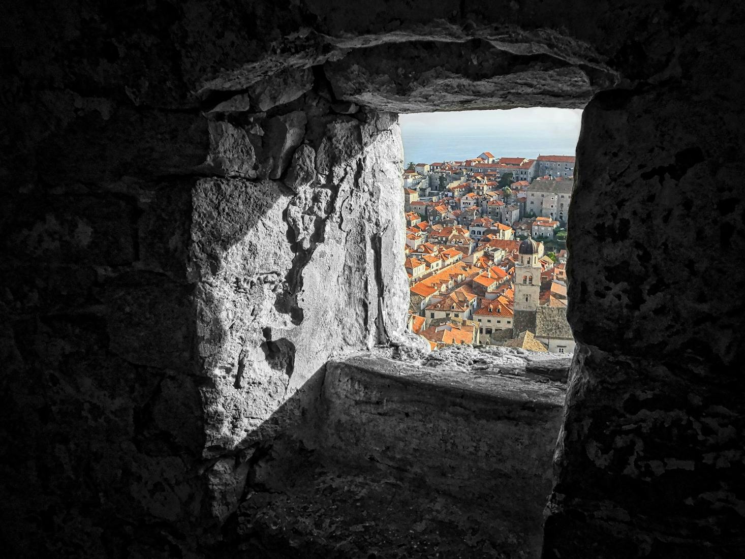 Dubrovnik Old Town seen through an ancient stone wall in Dubrovnik, Croatia