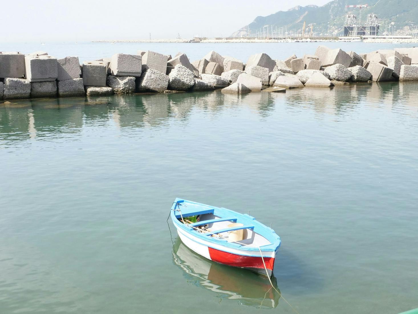 Mare di Salerno, con baia di scogli e barchetta in primo piano