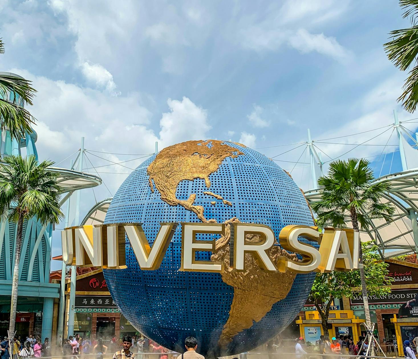 The universal logo on a globe with palm trees and cloudy skies