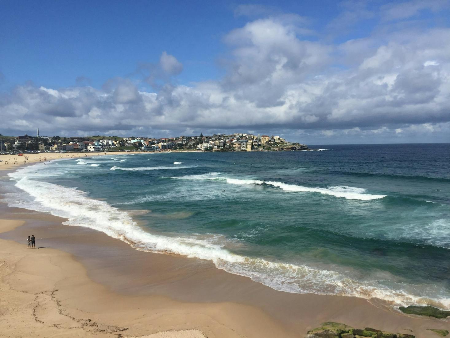 Bondi Beach's crashing waves with the city of Sydney and Bondi Junction in the distance