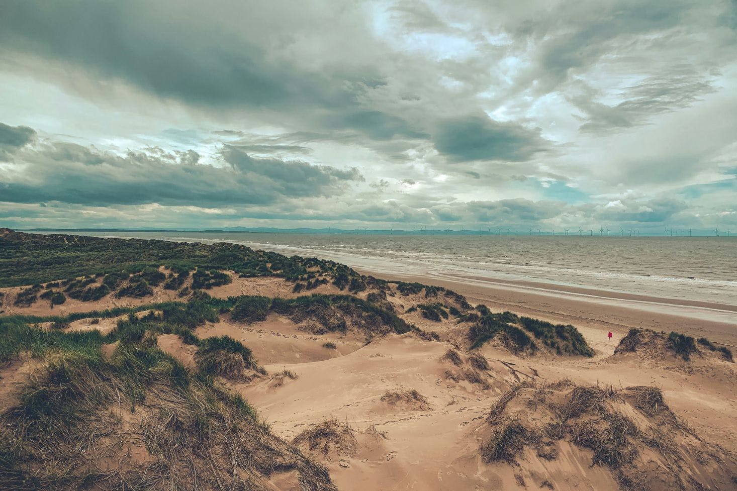 Formby Beach in Liverpool with sandy dunes covered in patches of grass