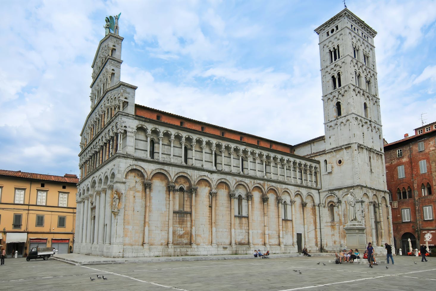 Vista laterale sulla chiesa di San Michele in Foro a Lucca, in piazza san Michele, con cielo azzurro sullo sfondo