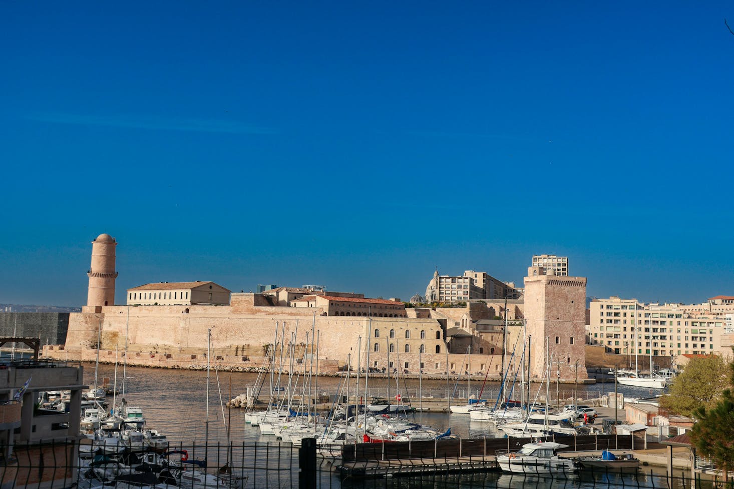 Vista sul porto a Marsiglia, con barche in primo piano e cielo azzurro sullo sfondo