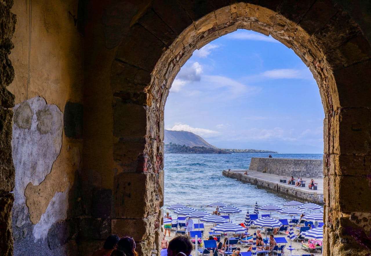 Scorcio sul mare e sugli ombrelloni da una porta medievale del centro del paese di Cefalù