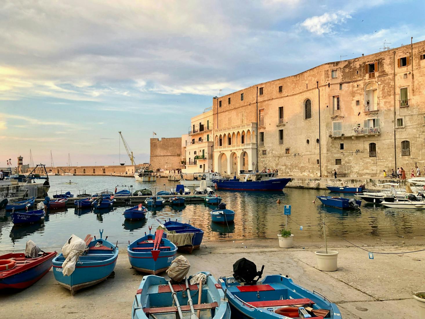 Vista sul porticciolo di Monopoli, Puglia, con barchette in primo piano e edifici sulla destra