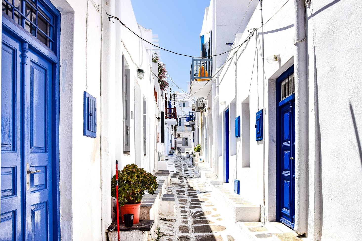 Tipico vicolo di Mykonos, con case bianche e porte e finestre blu