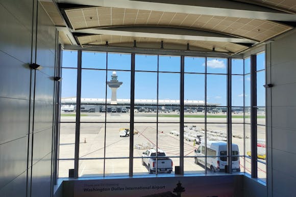 View through the window of Washington D.C. Dulles Airport, showing the control tower and airport vehicles