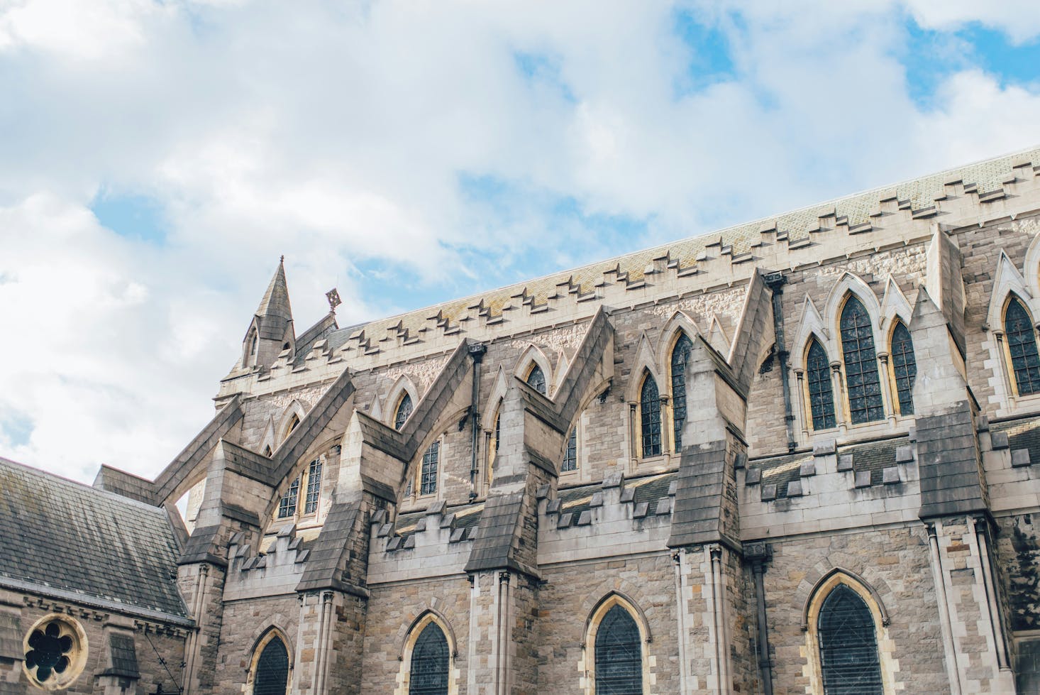 Dettagli della parte superiore della Cattedrale a Dublino, cielo azzurro e nuvole bianche sullo sfondo