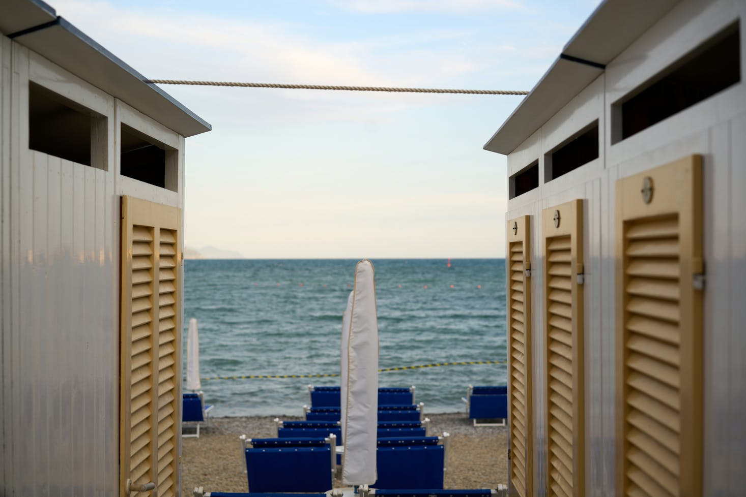 Spiaggia di Santa Margherita Ligure, con cabine ai lati e ombrellone e spiaggia in mezzo, sullo sfondo