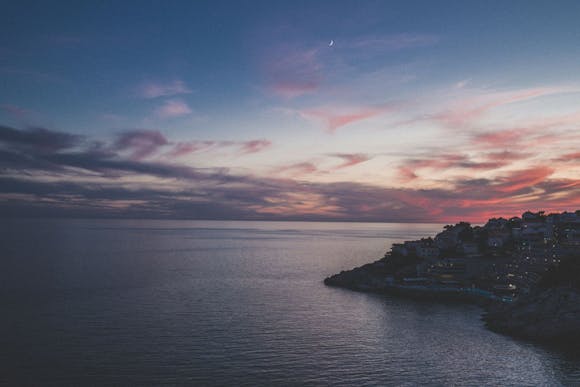 Purple sunset over the Adriatic Sea and the Dubrovnik visible in the right corner