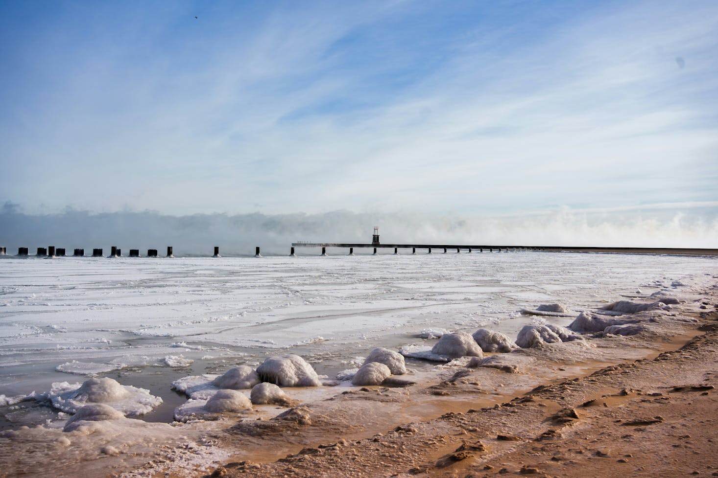 The rocky shore of North Avenue Beach in Chicago with a pier in the distance