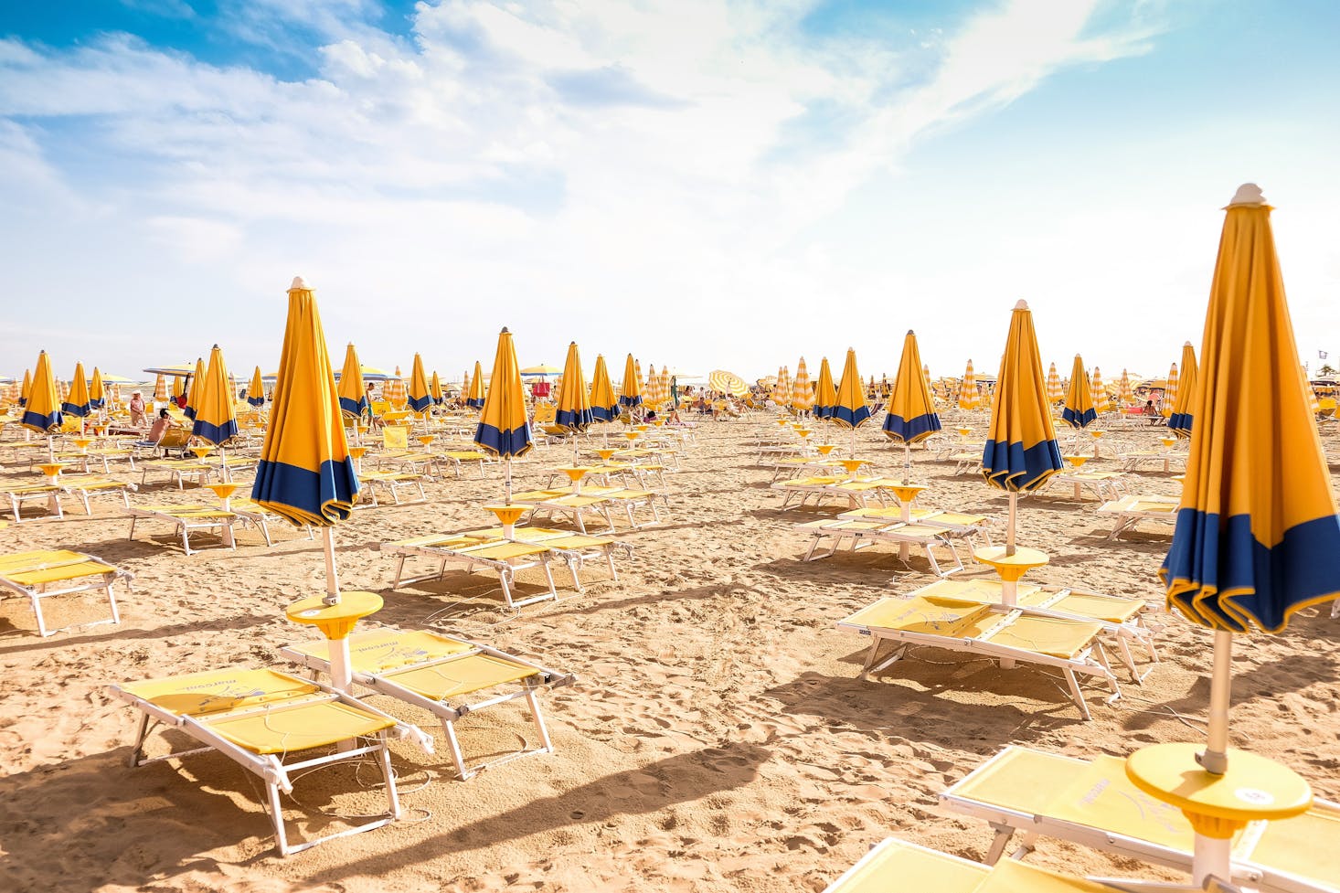 Yellow loungers and beach umbrellas lined up at Lido di Jesolo near Venice