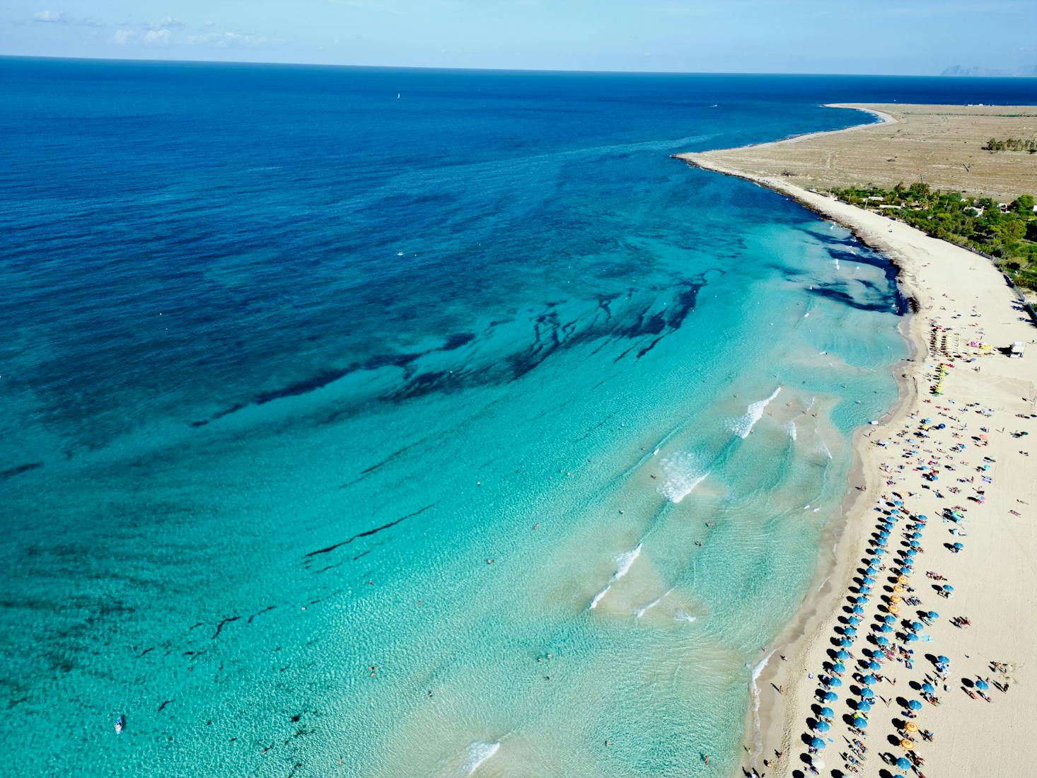 The clear waters and white sands with loungers along the shore in San Vito lo Capo near Palermo