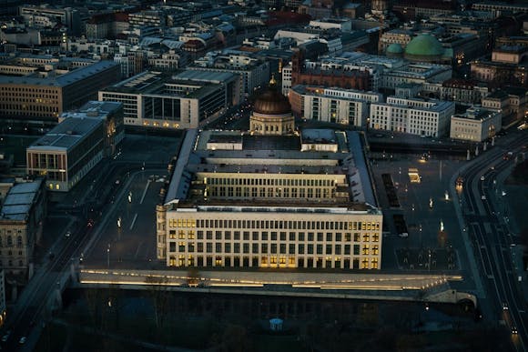 A night cityscape of Berlin with Humboldt Forum Berlin in the center, surrounded by other buildings 