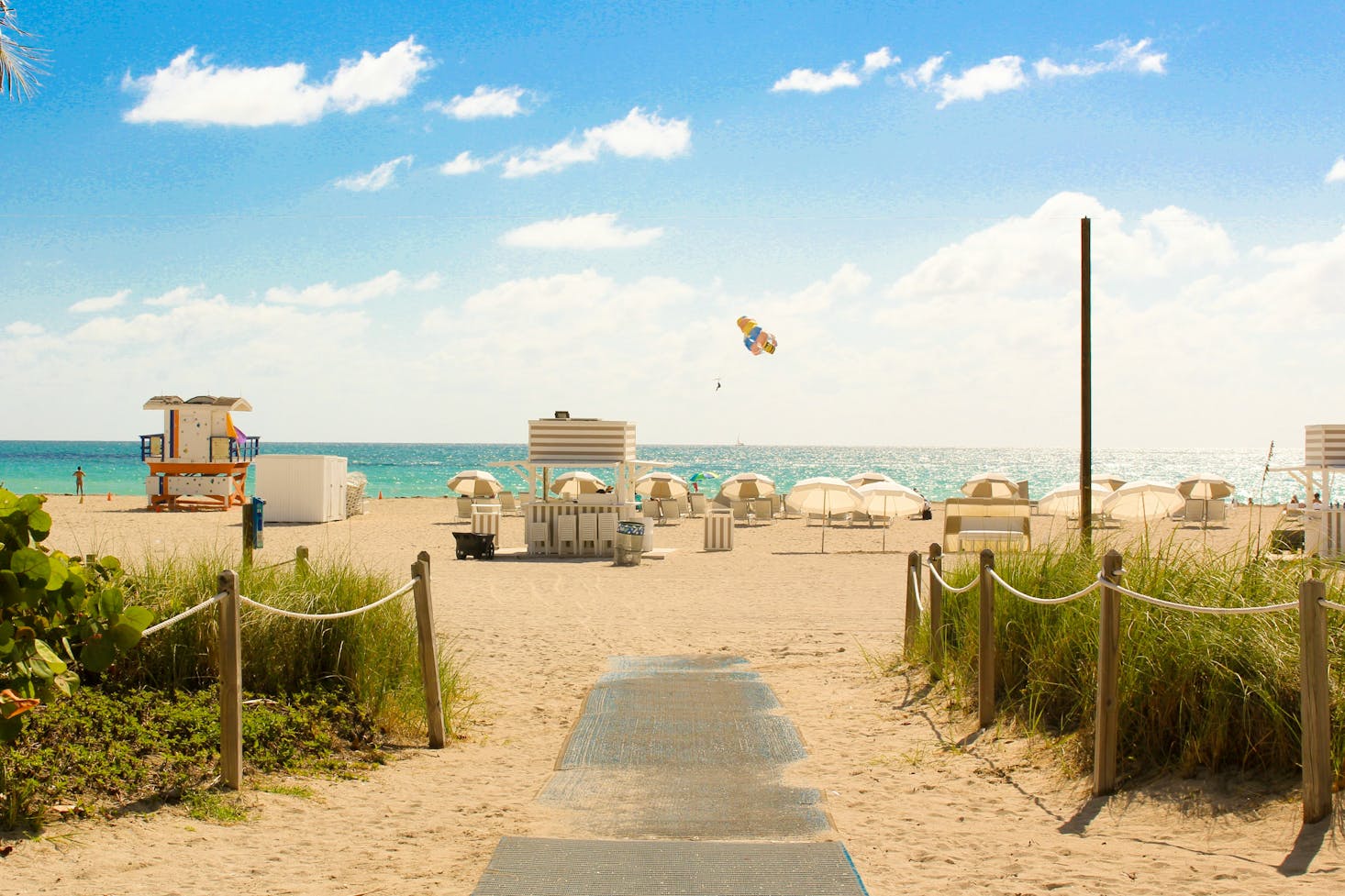 Plage avec des parasols et des petites maisons face à la mer à Miami Beach, USA