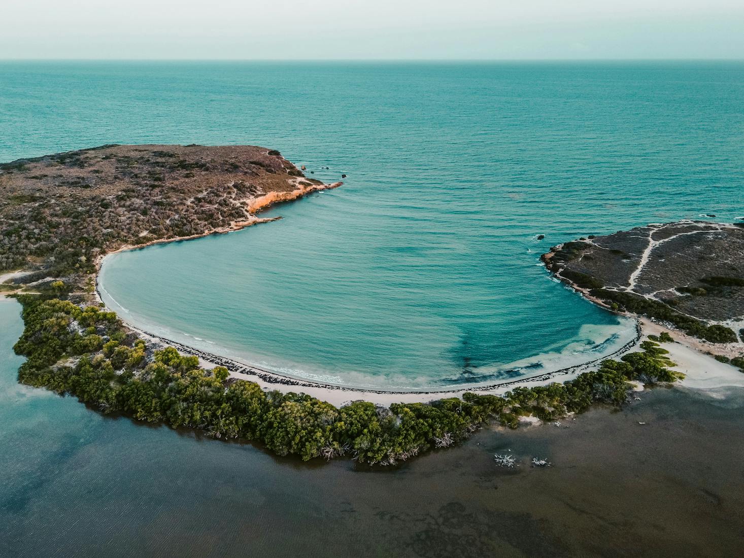 The crescent-shaped beach of Playa Sucia at Cabo Rojo from above