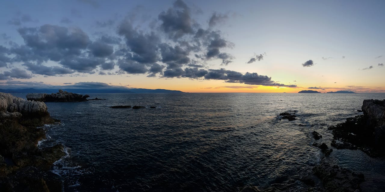 Piscina di Venere a Milazzo, Sicilia, con cielo al tramonto sullo sfondo Piscina di Venere a Milazzo, Sicilia, con cielo al tramonto sullo sfondo