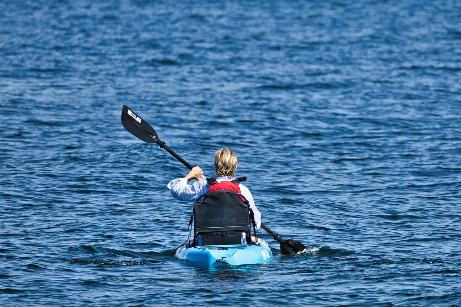 A person kayaking in the blue water of Palm Beach near Sydney