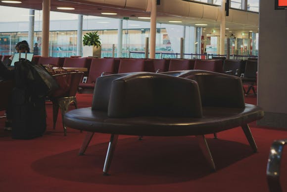 Burgundy leather seating at Charles de Gaulle Airport in Paris with a window view in the background