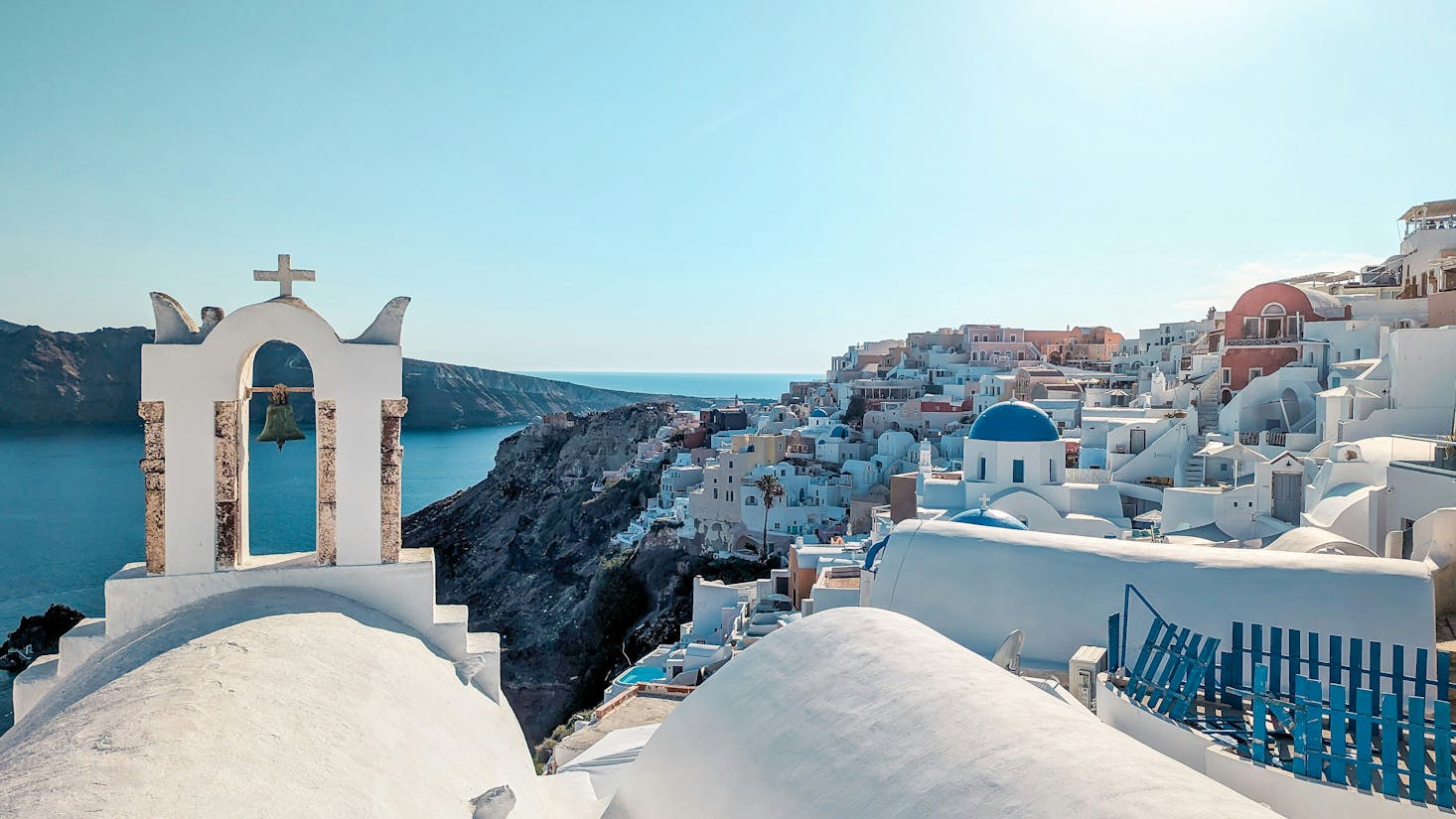 Tipici edifici bianchi con tetti blu a Santorini, con mare e cielo azzurro sullo sfondo