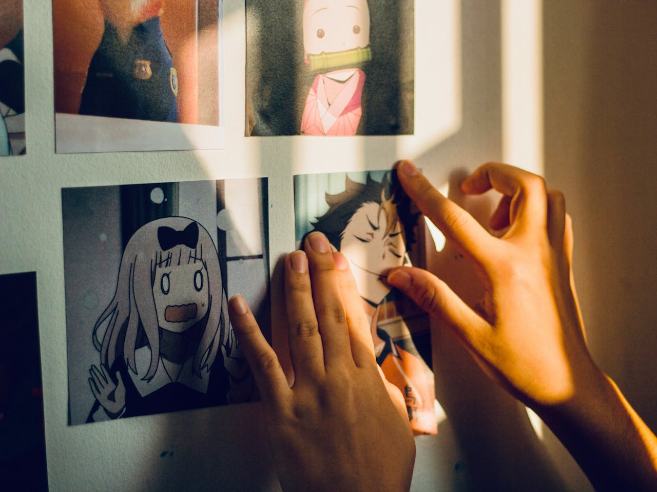 Person setting up photos of animated characters at a convention, preparing for MegaCon Orlando