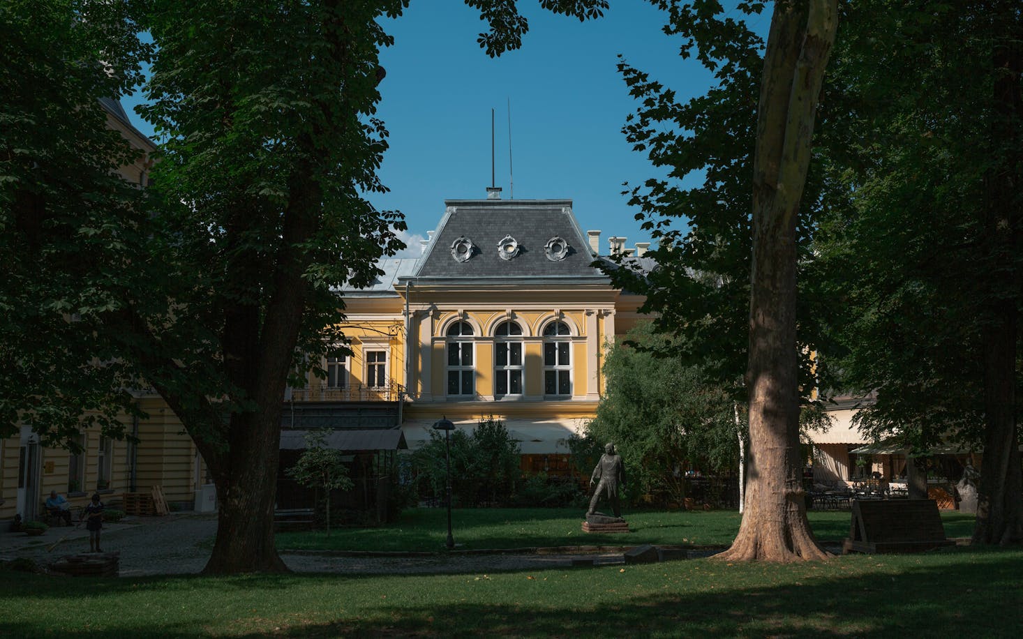 Galleria Nazionale di Sofia, Bulgaria, con alberi e verde in primo piano e cielo azzurro sullo sfondo