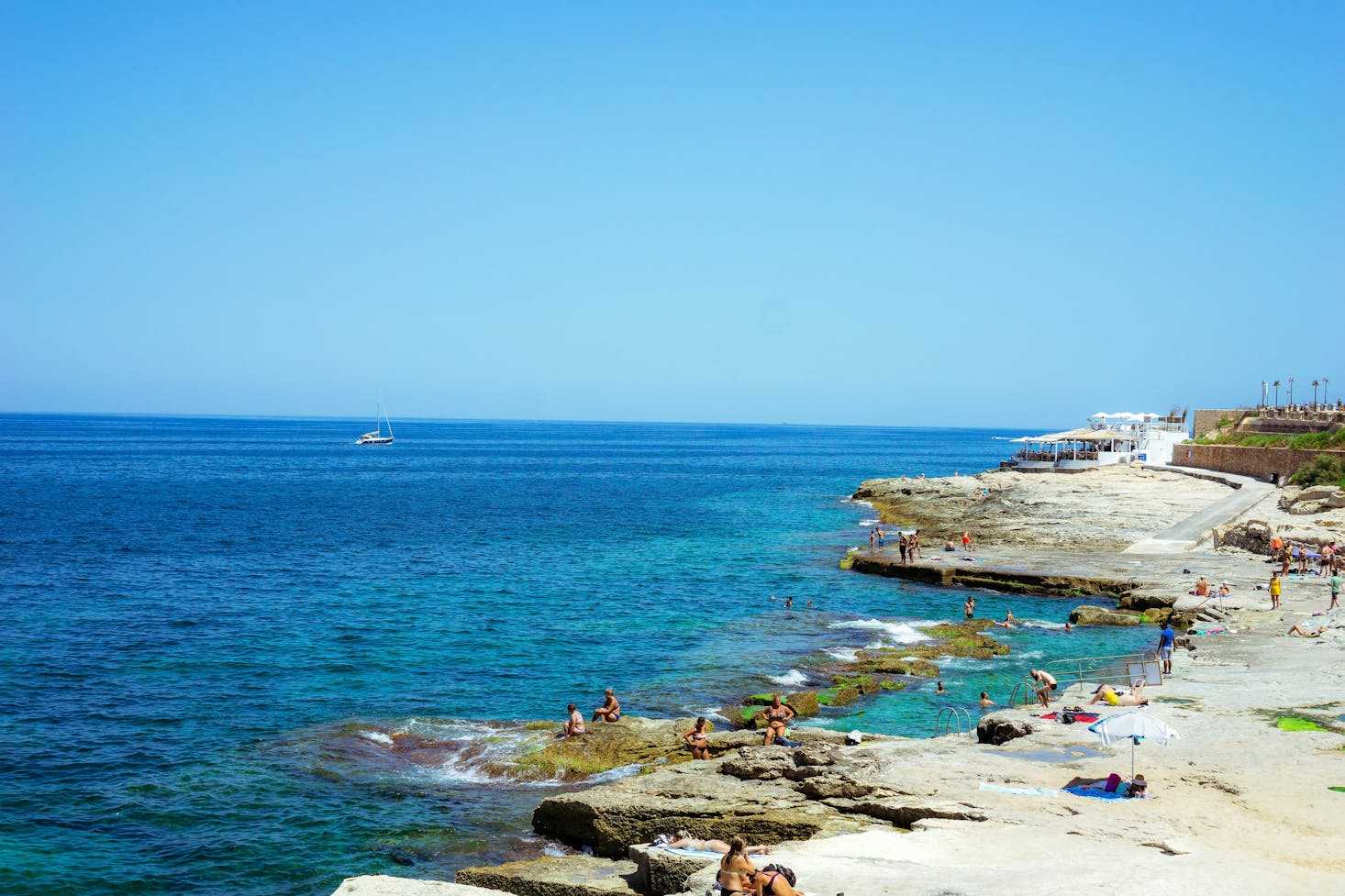 Bagnanti al mare a Sliema, con acqua cristallina e cielo azzurro