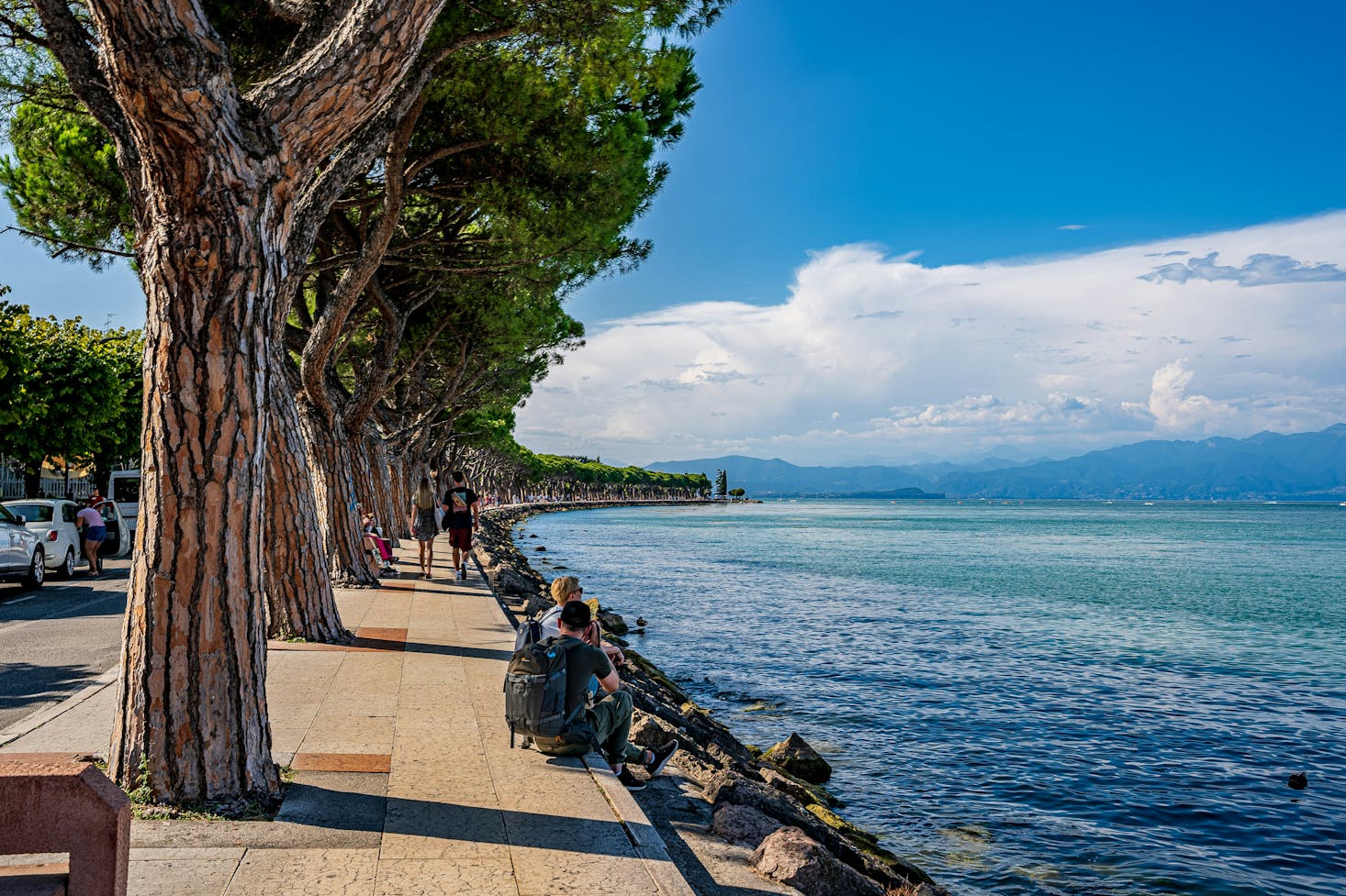 Lungolago alberato a Peschiera del garda, con alberi sulla sinistra e cielo azzurro