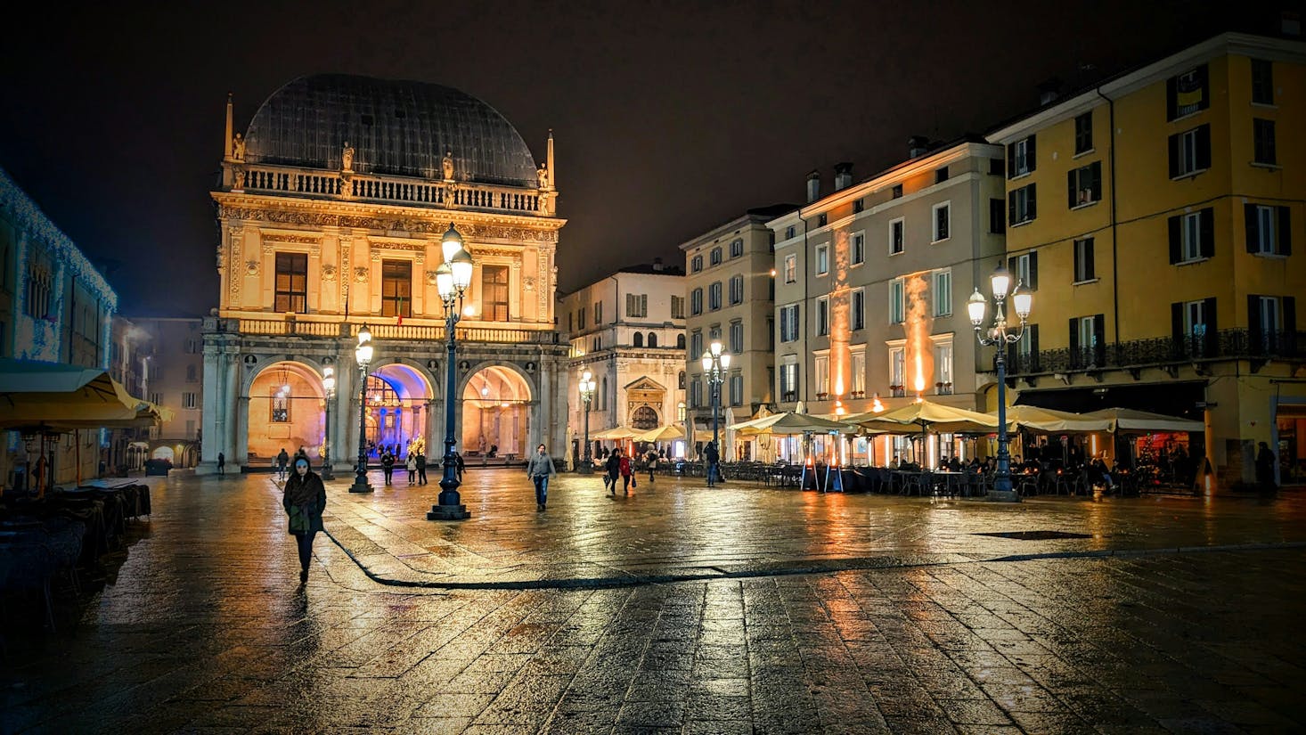 Piazza della Loggia a Brescia di notte, con palazzi illuminati 