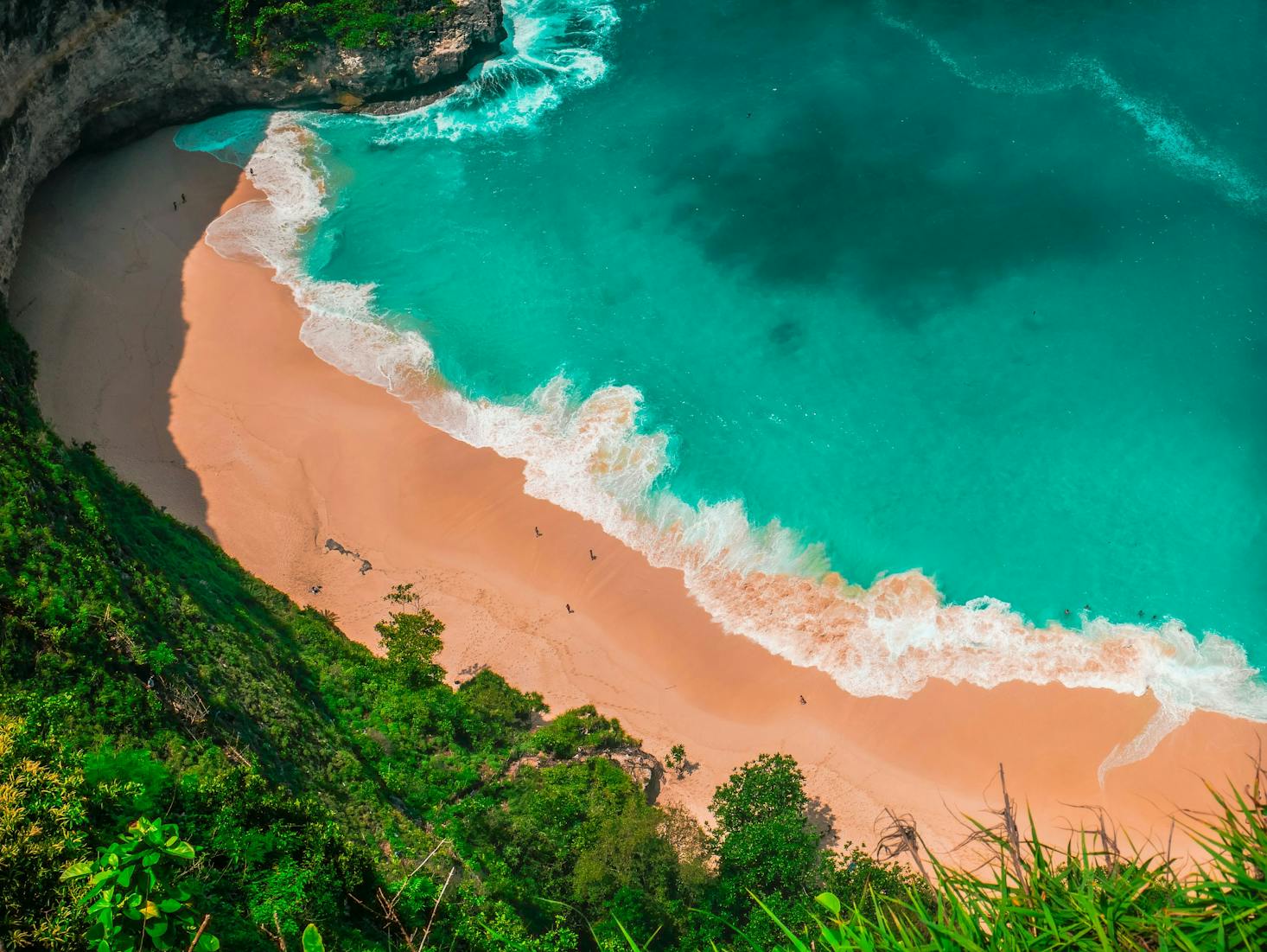 Vista dall'alto su spiaggia paradisiaca di Bali, con acqua cristallina, sabbia dorata e vegetazione fitta