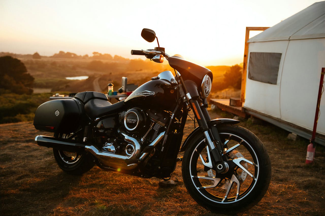 Parked black Harley Davidson motorbike with a stunning brown sunset in the background