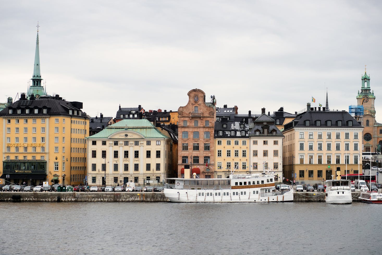 Zona di Gamla stan a Stoccolma, con edifici tipici affacciati sull'acqua e cielo grigio sullo sfondo