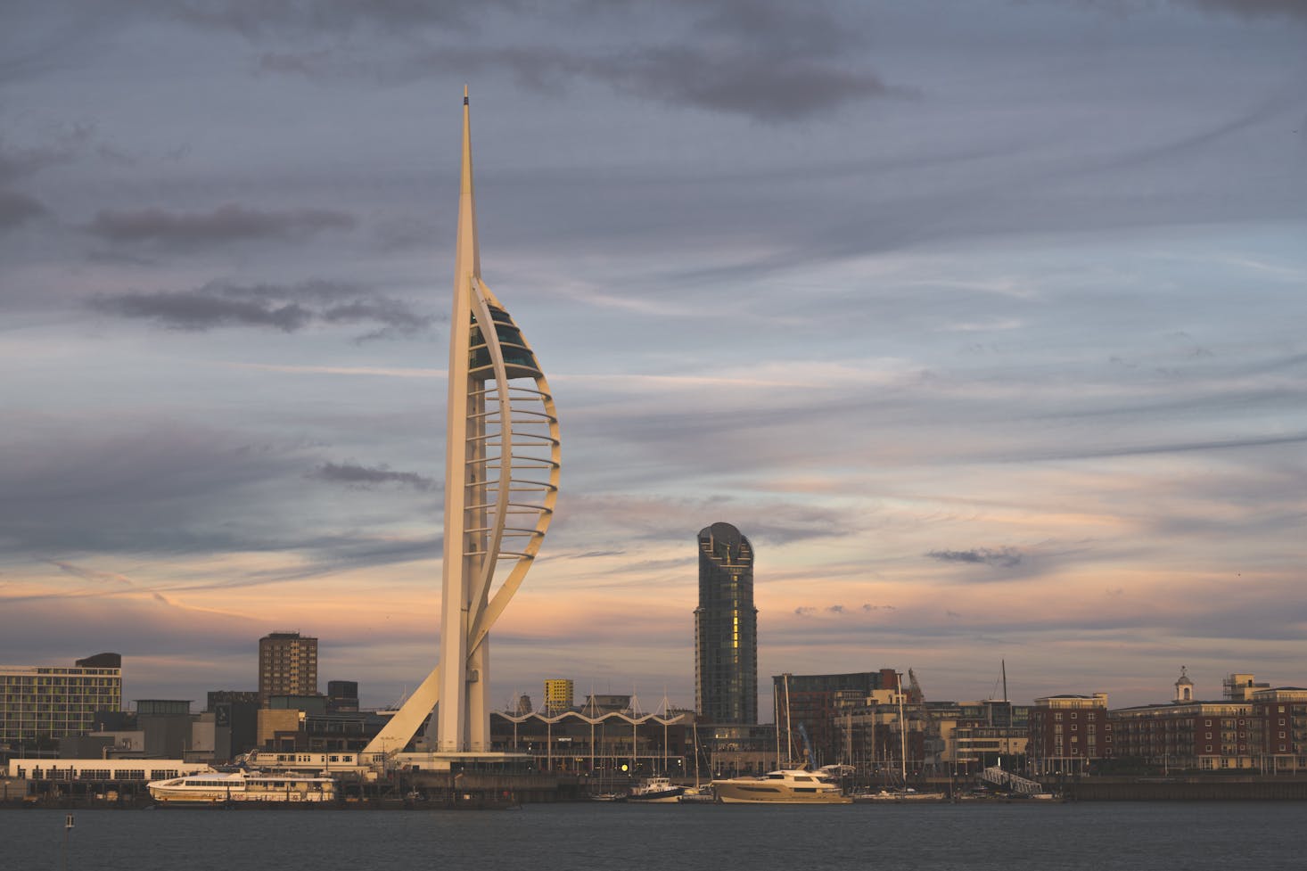 The white Spinnaker Tower in Portsmouth at sunset with dark clouds 