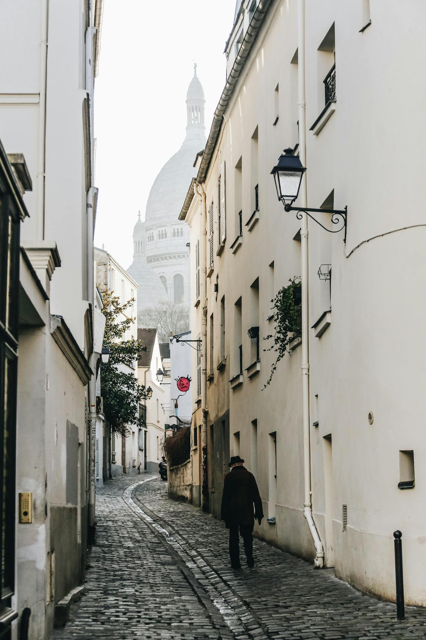 A narrow alley with white buildings in Paris's Montmartre neighborhood