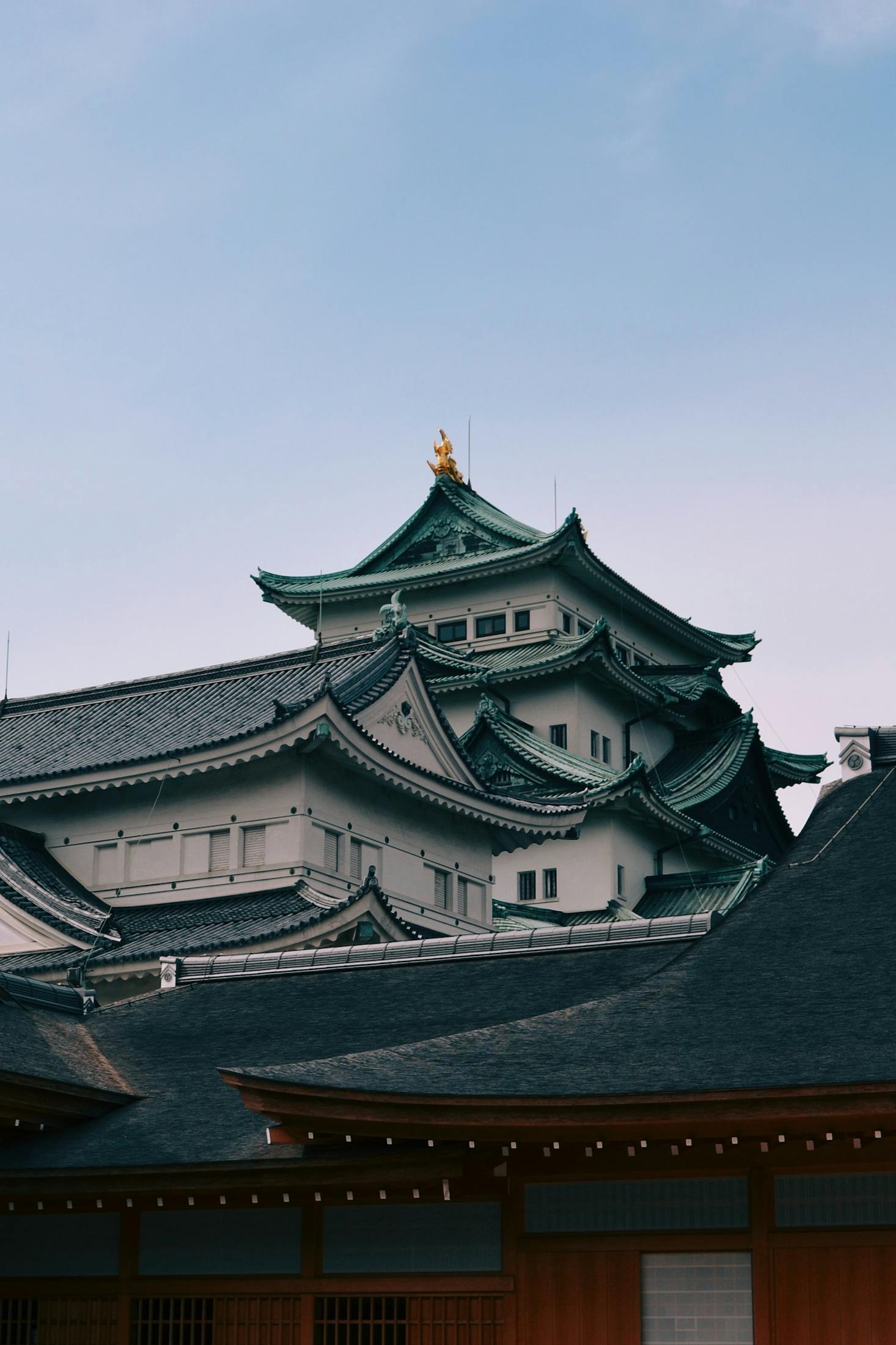 The white building with green roofs of Nagoya Castle with nearby luggage storage