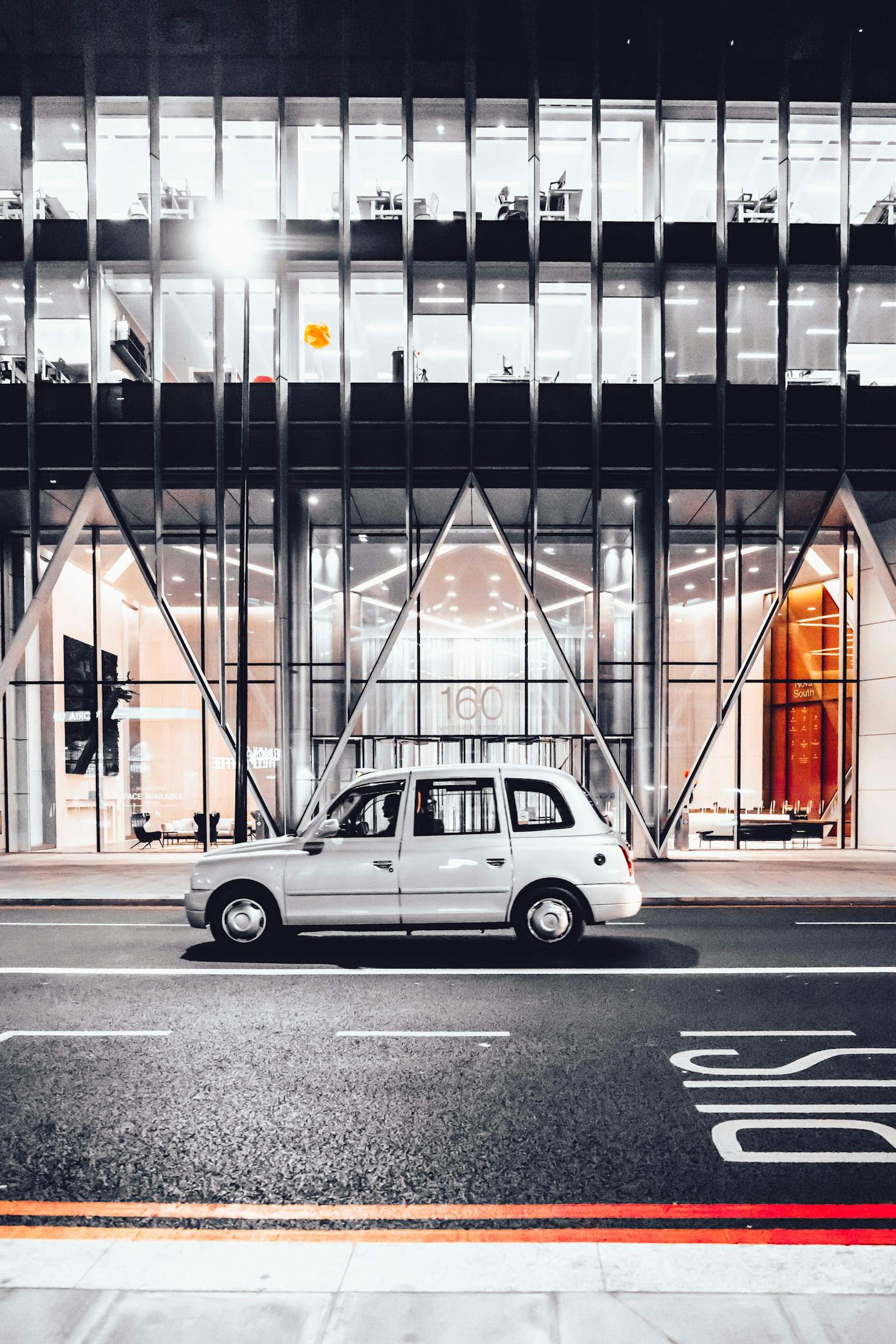 Car passing in front of the modern facade of Victoria Station in London