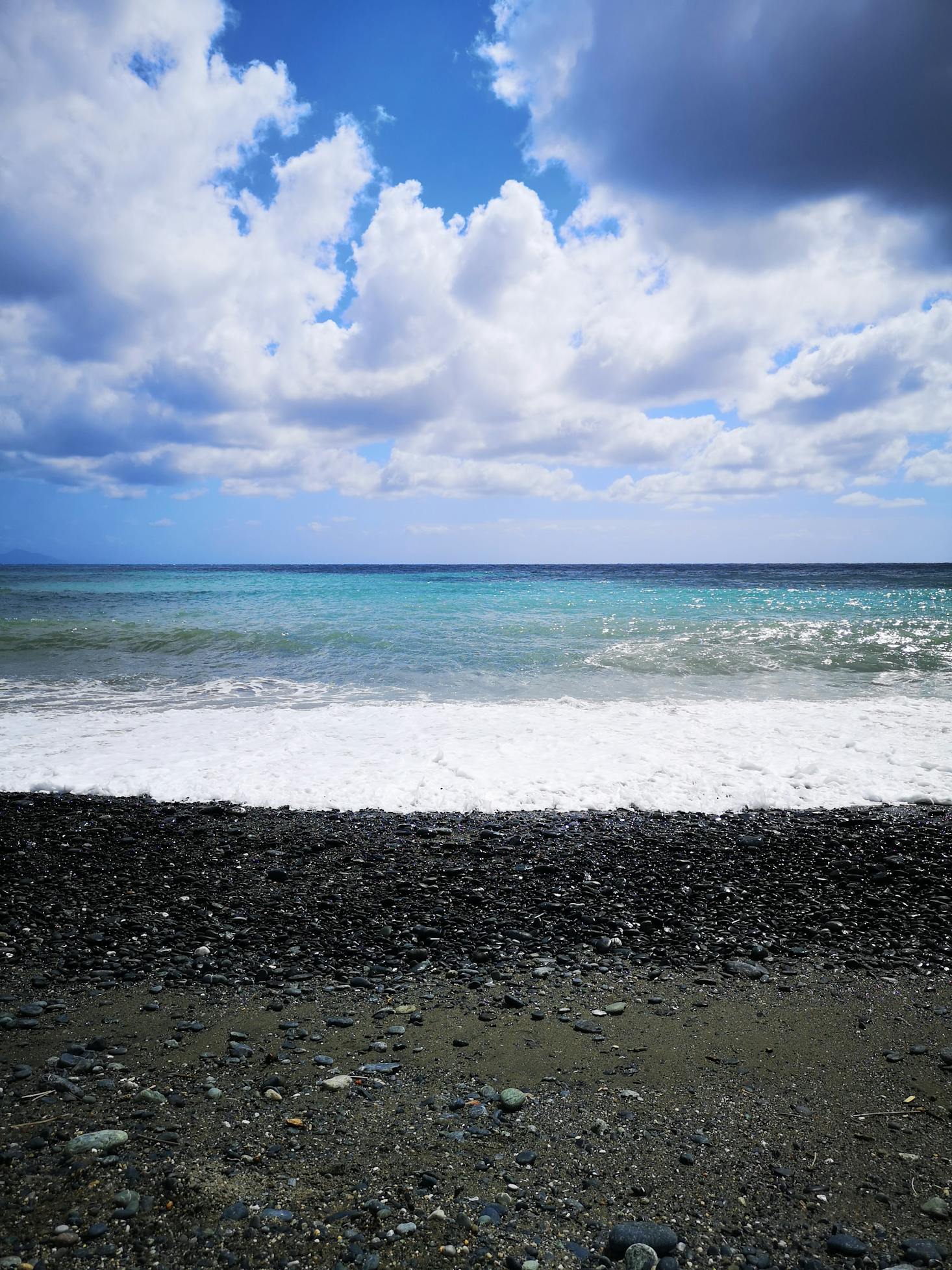Arenzano Beach near Genoa with dark pebbles and clear, turquoise water