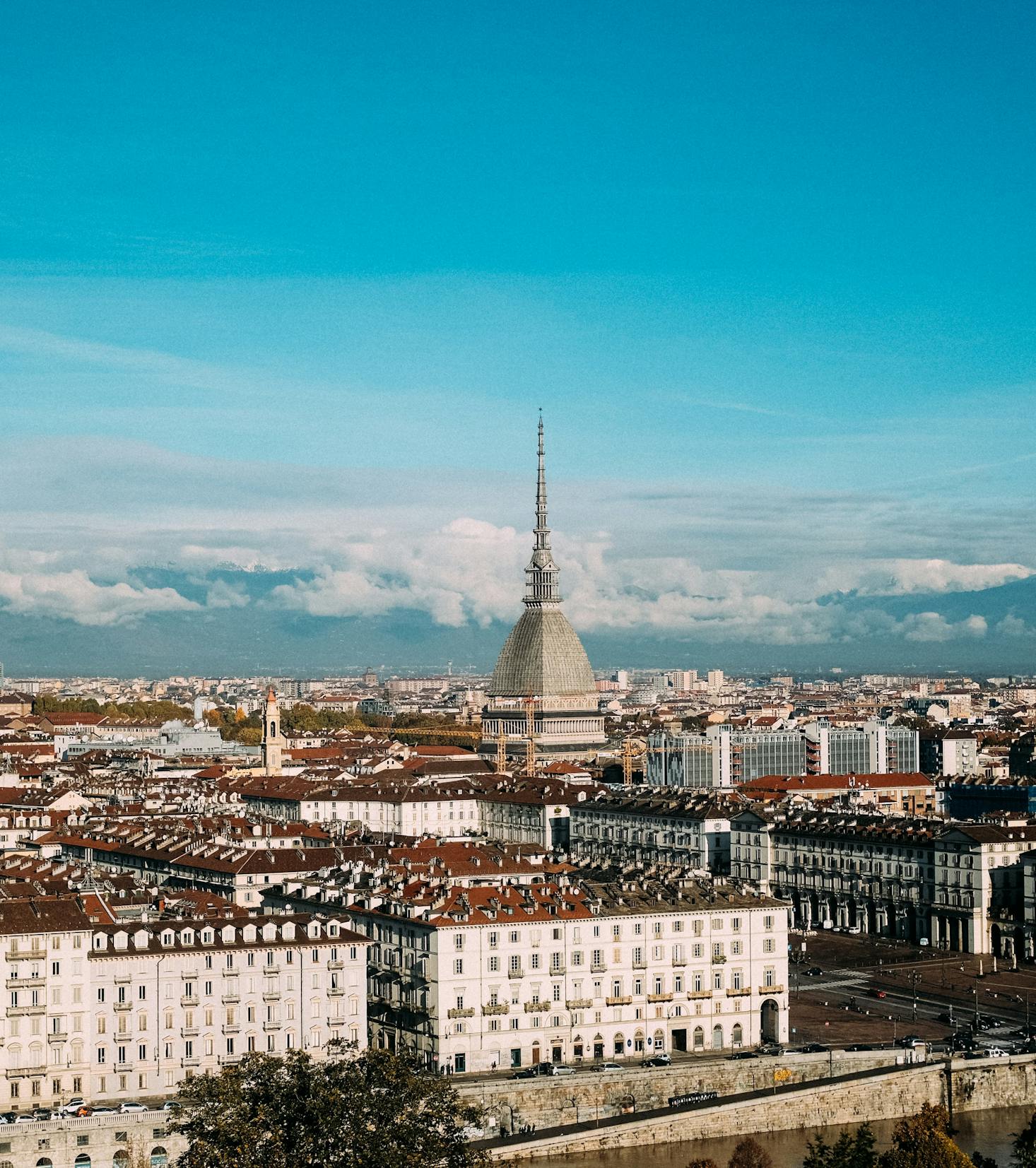 A majestic building sits in the center of Turin, Italy, framed against a blue sky