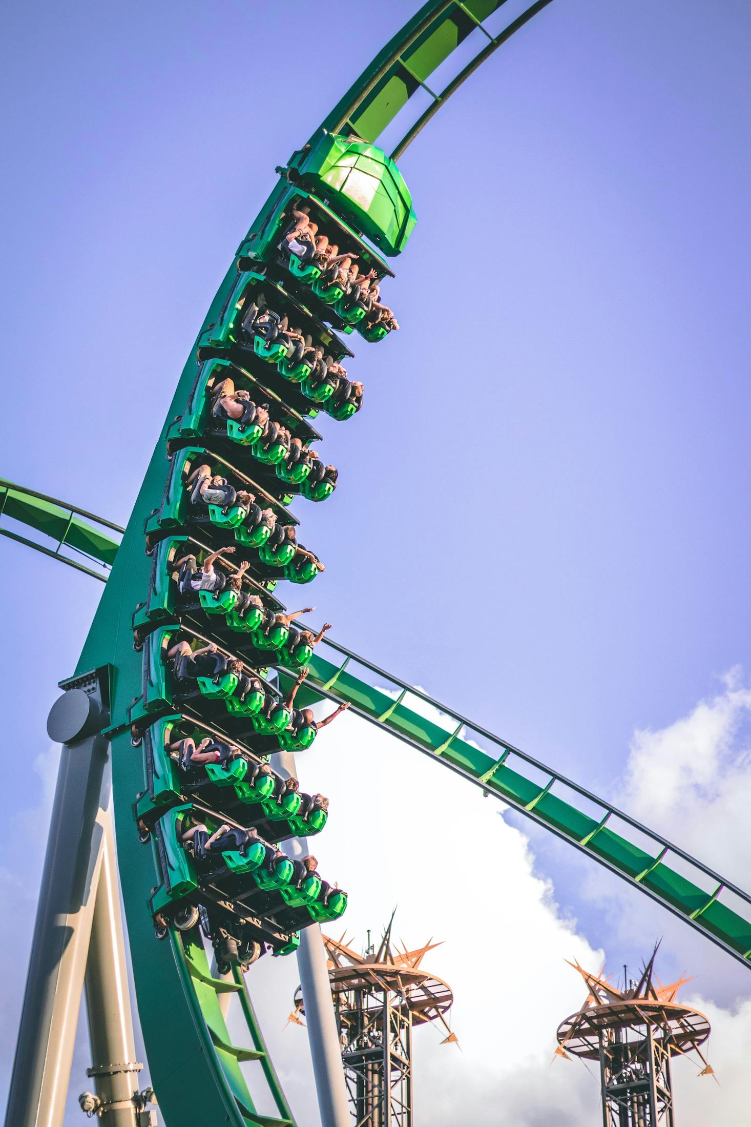 Rows of 4 riders on a green roller coaster at Universal Studios Hollywood