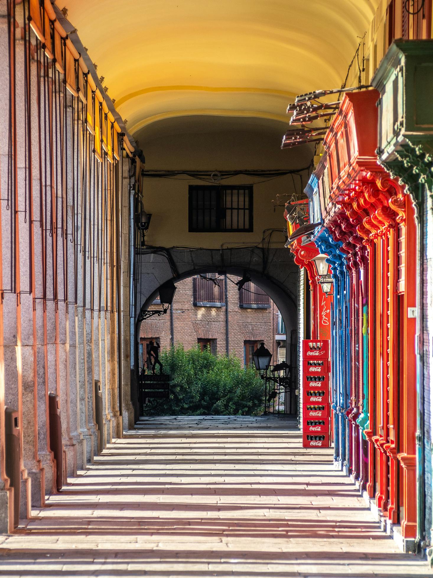 Colorful pillars with sunlight and shadows that line Madrid's Plaza Mayor