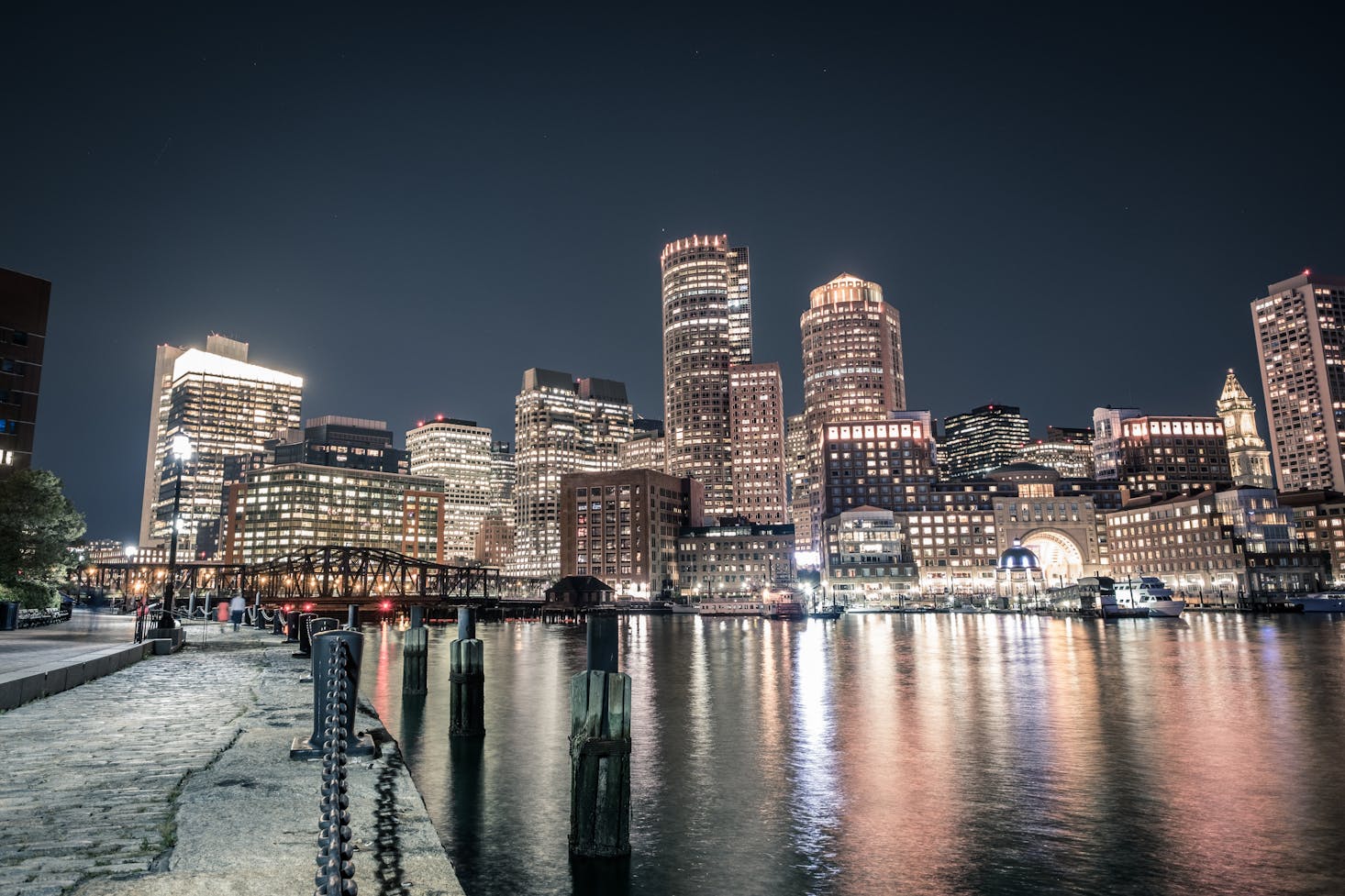 View of Long Wharf in Boston at night with lit-up skyscrapers across the water