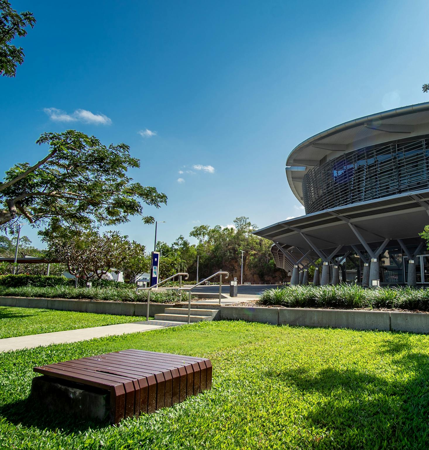 An oval shaped building overlooks a green park in Darwin, Australia