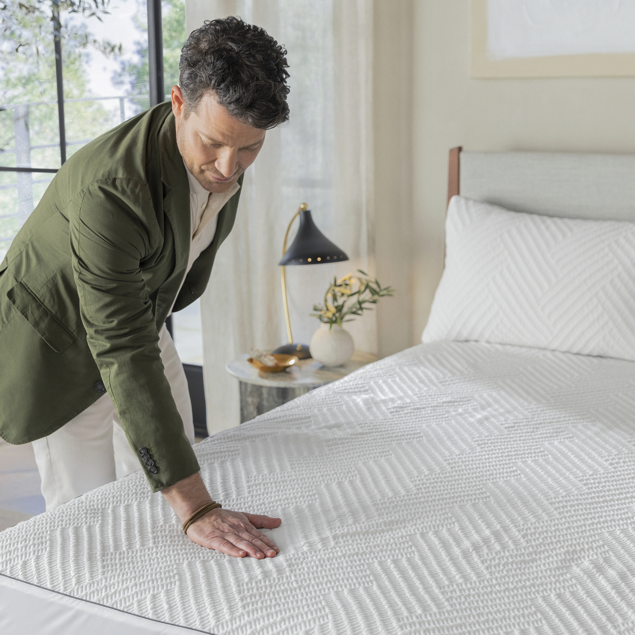 Nate Berkus touching the Limited Edition Beautyrest + Nate Berkus Mattress Protector