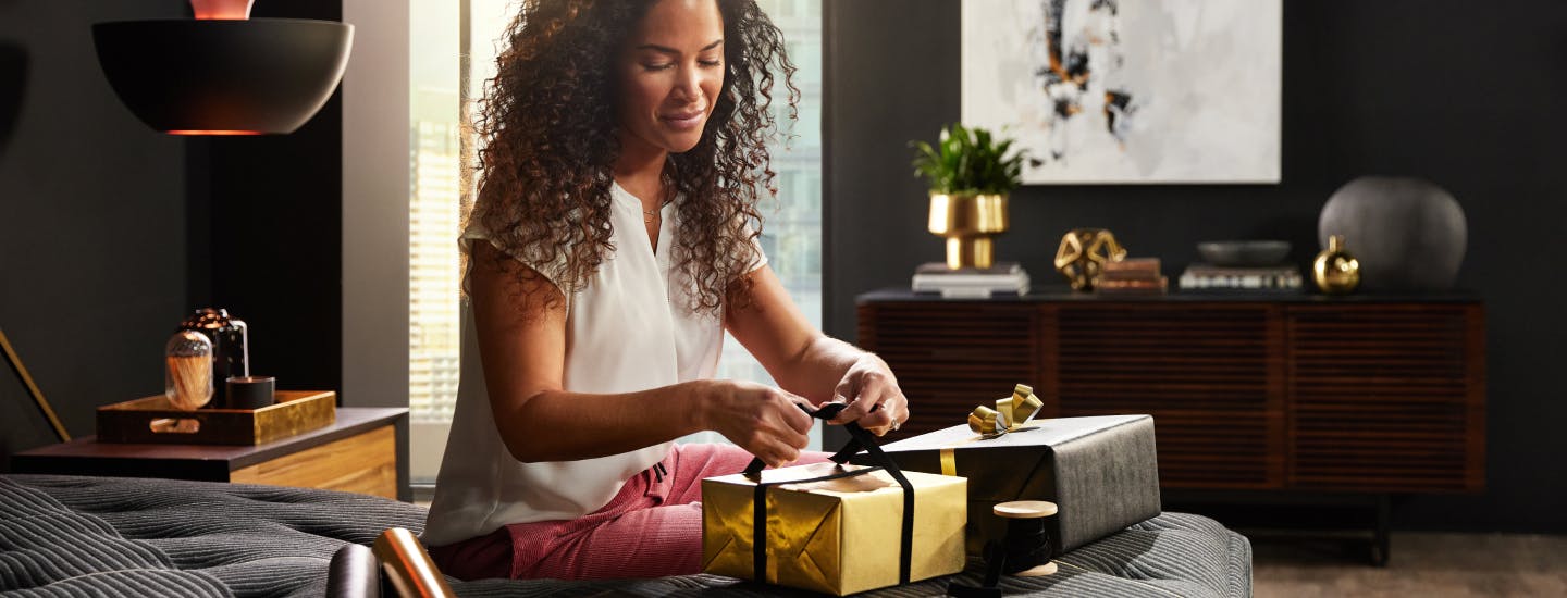 Woman wrapping gifts on a Beautyrest Black Mattress