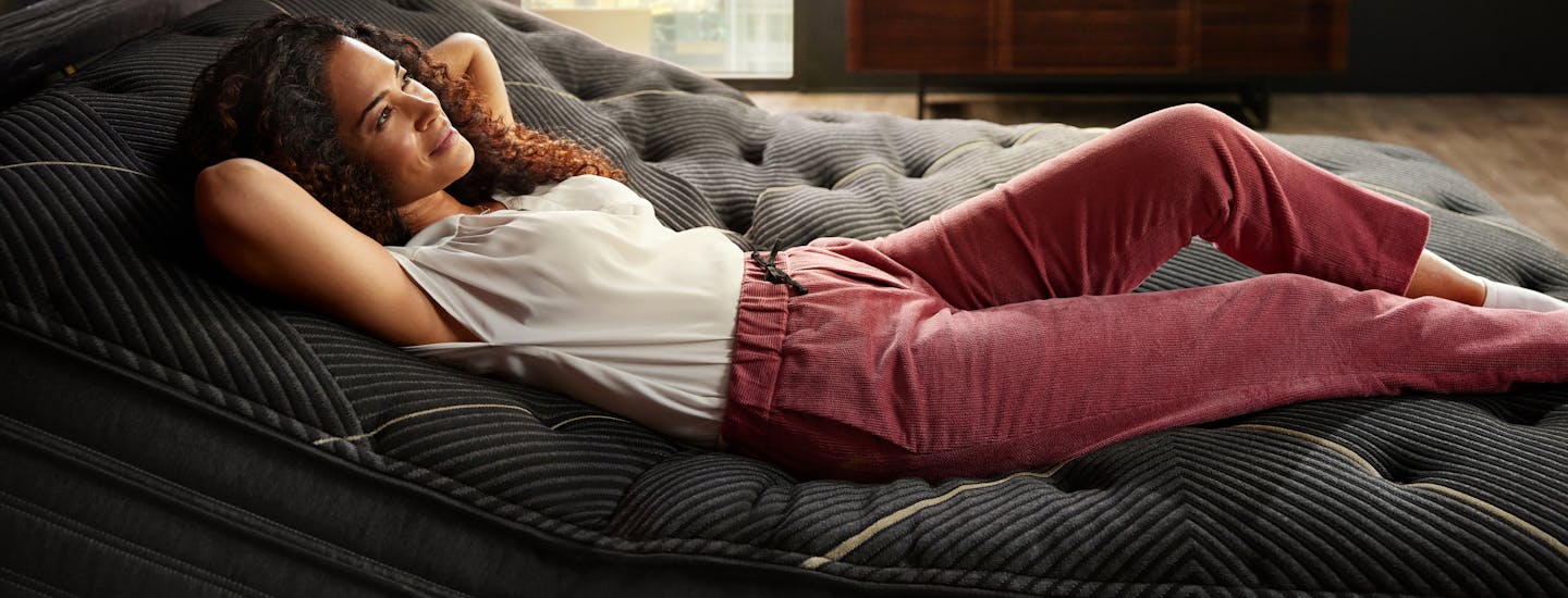 Woman laying with her arms behind her bed on a Beautyrest Mattress