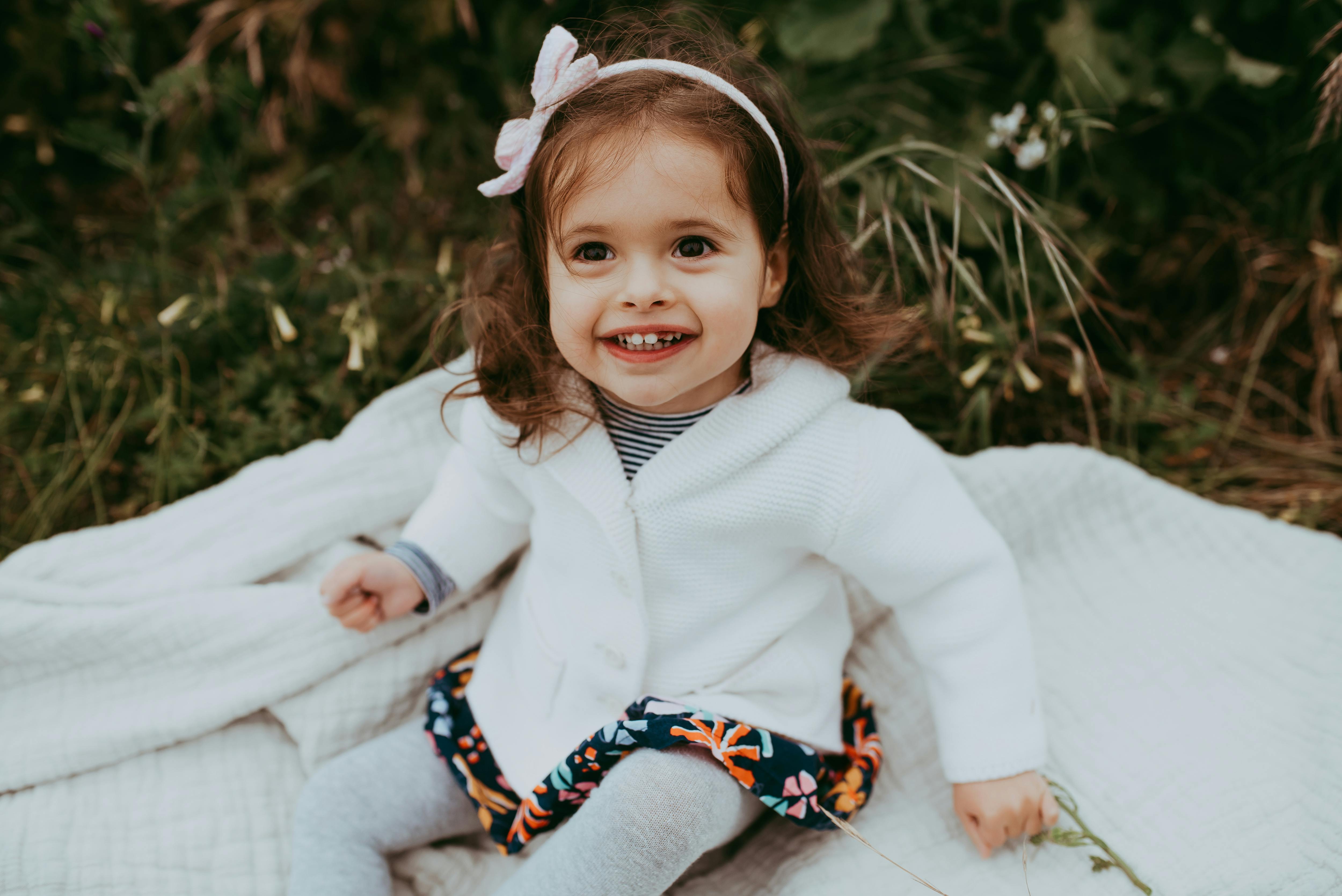 Girl with cerebral palsy sitting on a blanket