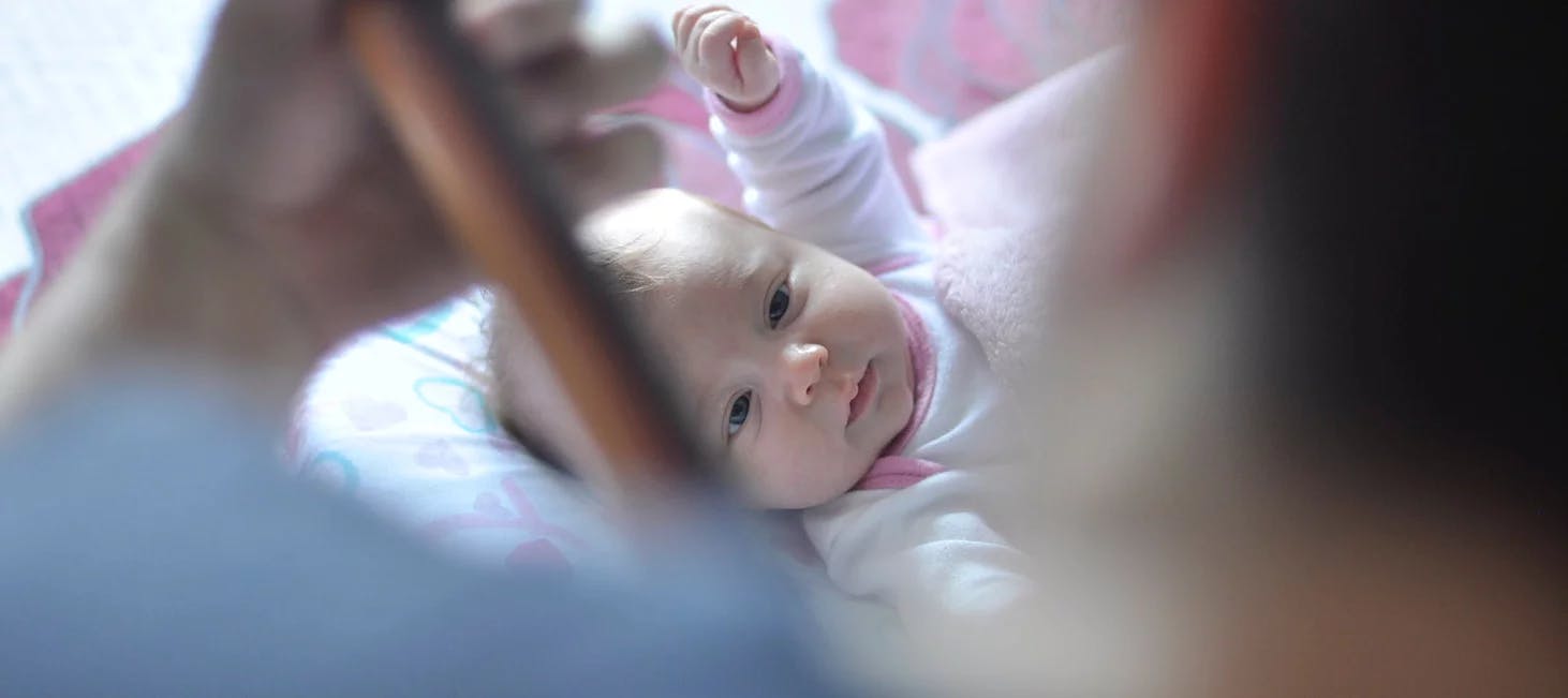 Baby listening to man playing the guitar